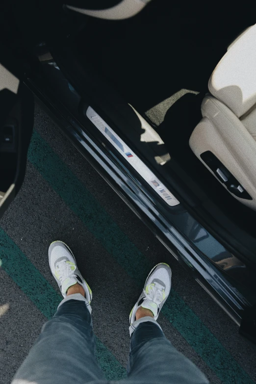 a pair of feet wearing sneakers stand next to a chair