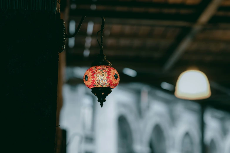 an elaborate decorated red lantern hangs from the ceiling