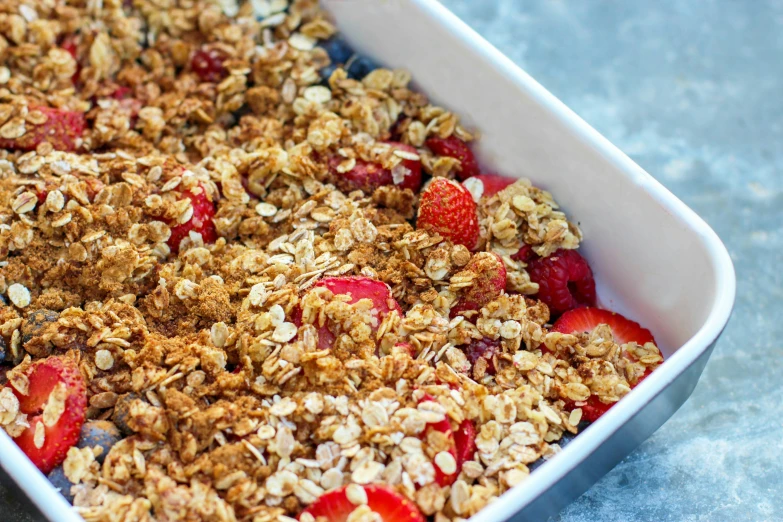 a white dish filled with muffin and strawberries