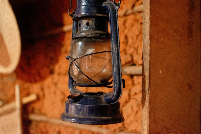 an old lantern hanging on a wall near bricks