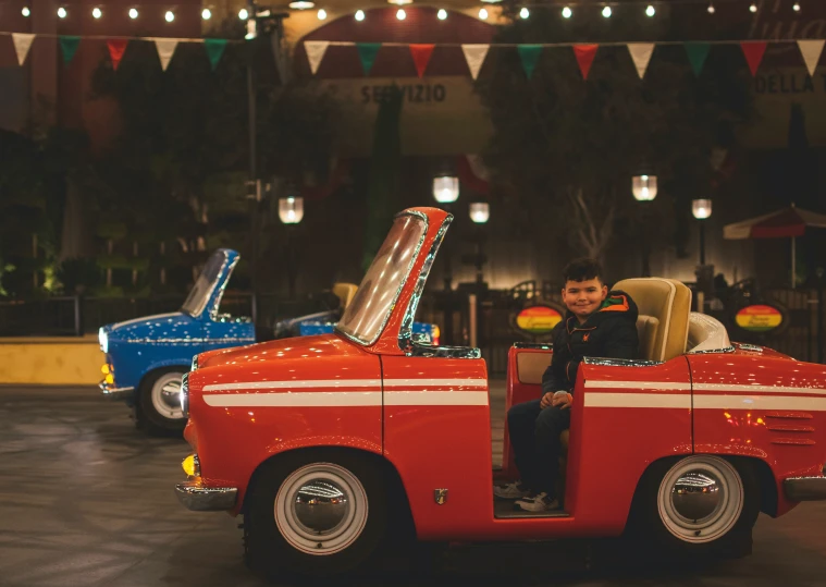 man driving on a small convertible car at night