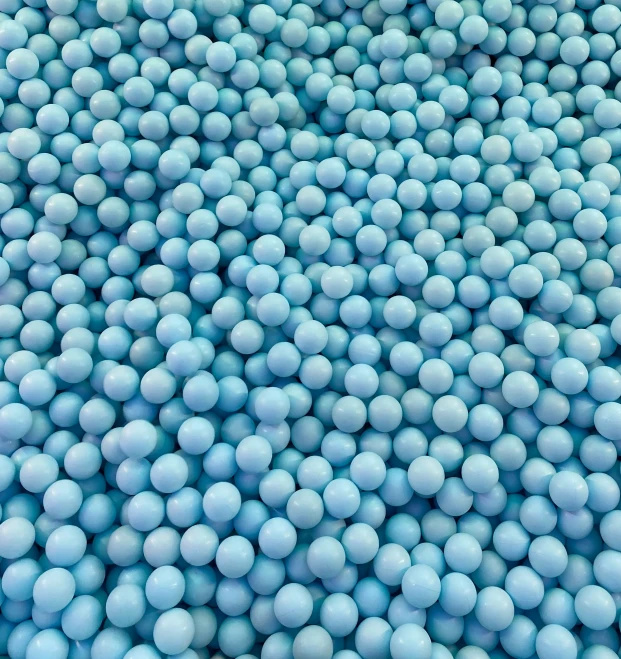 a bunch of blue balls are in a large container