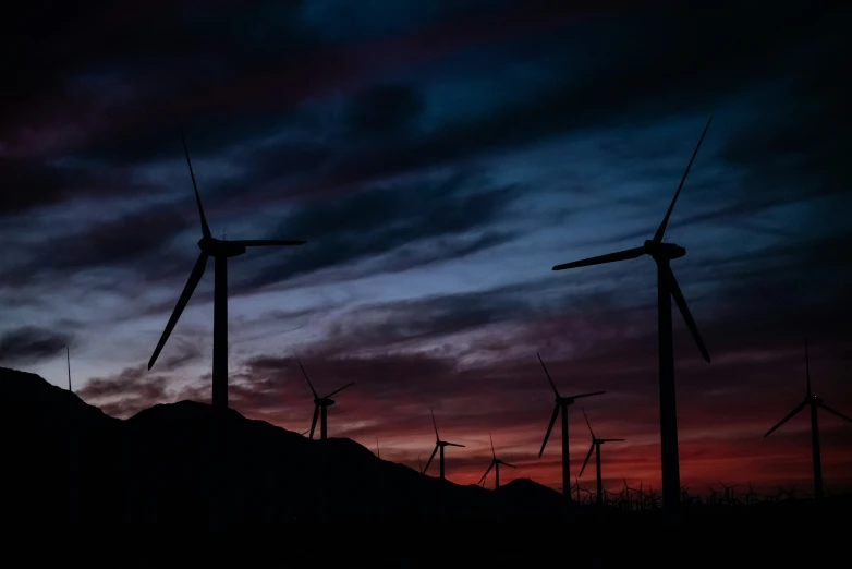 windmills on the hillside at sunset time