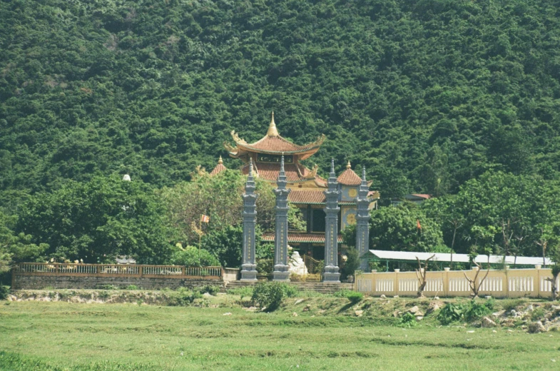 a pagoda with a statue next to a park and trees
