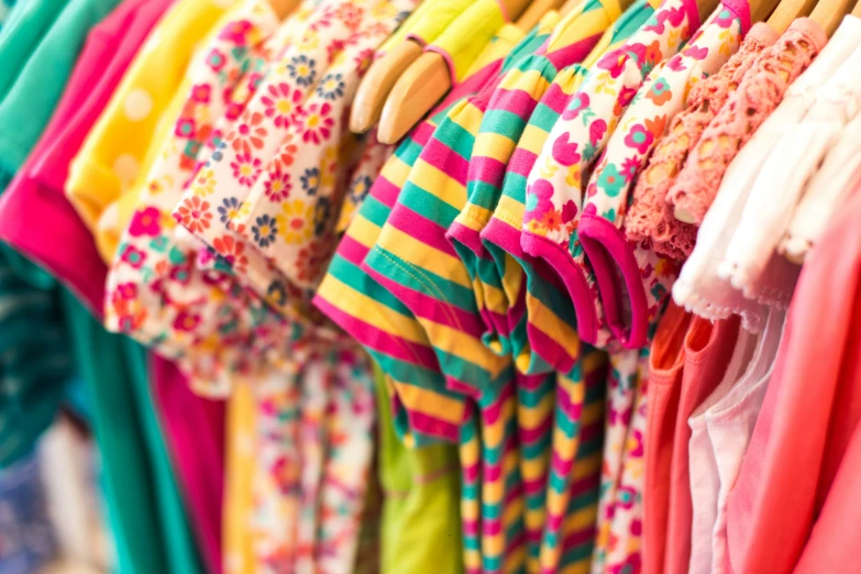 a rack of brightly colored clothing on hangers