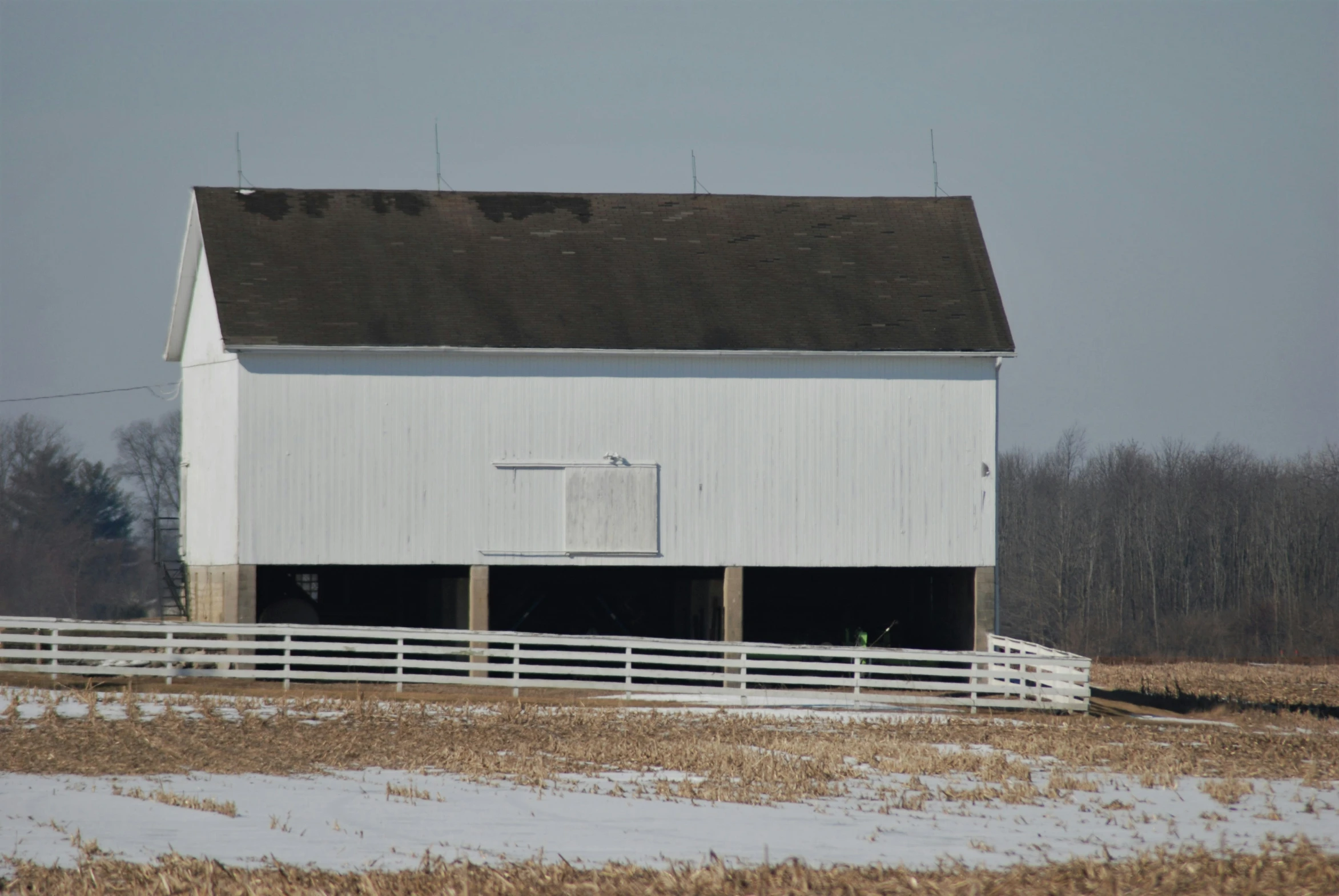 a barn with two doors and a fence