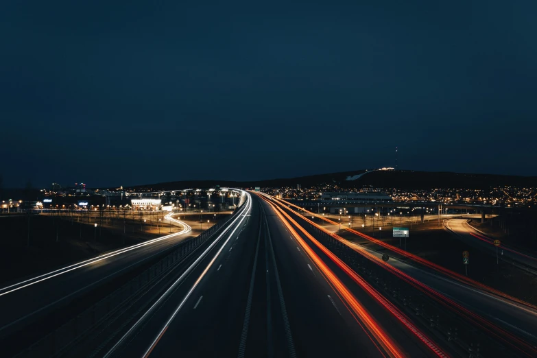 a dark road that is lined up with lights