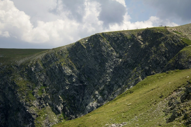 a hill with a large cliff in the background