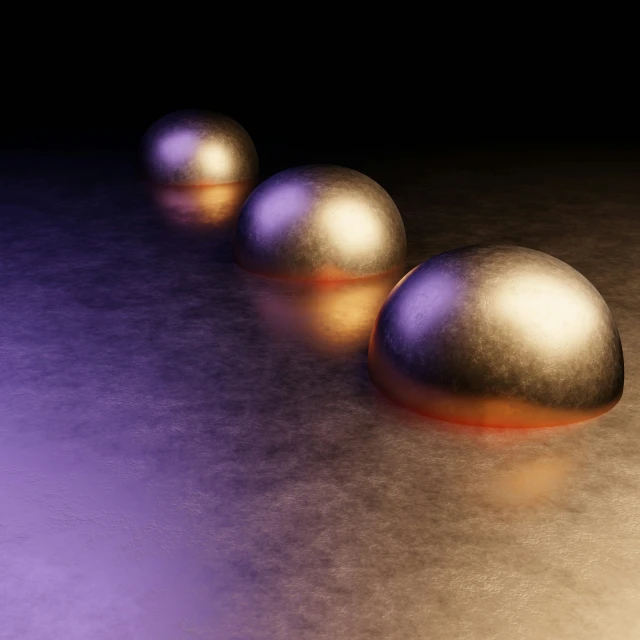 three golden metal balls on top of a purple surface