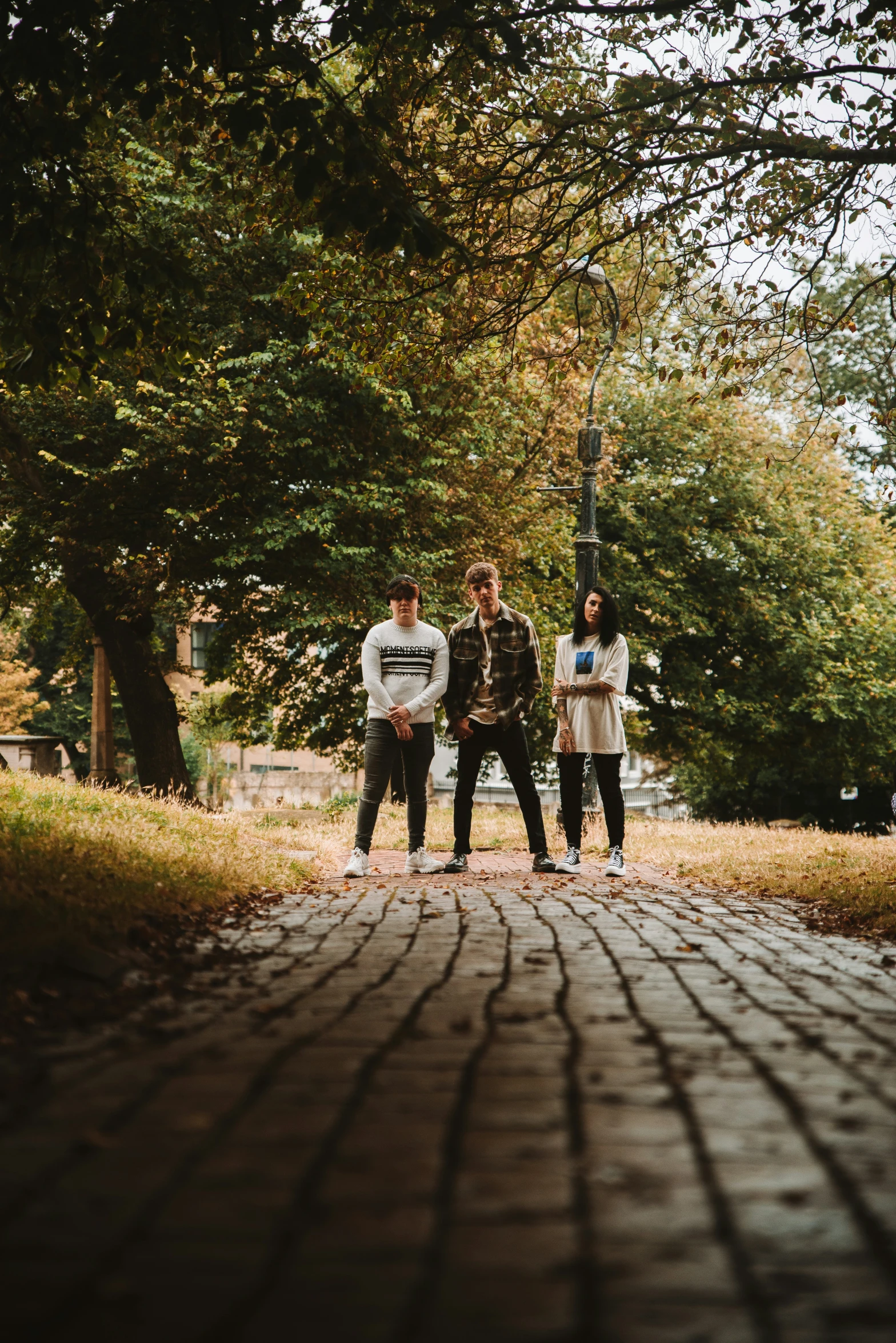 three people wearing white t shirts are standing together