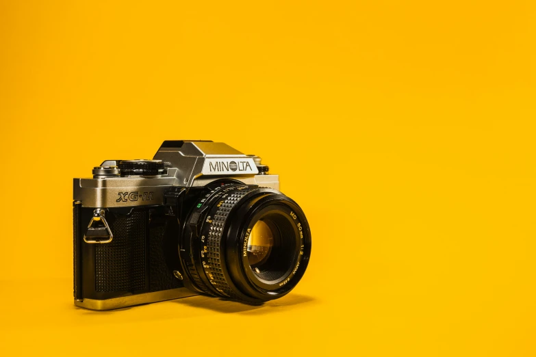 a vintage camera sitting on top of a yellow table