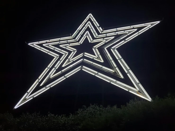 a big star decorated with white lights in the dark