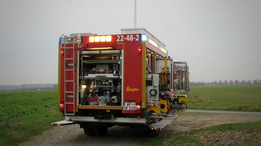 a fire truck with its doors open sitting on the side of a road