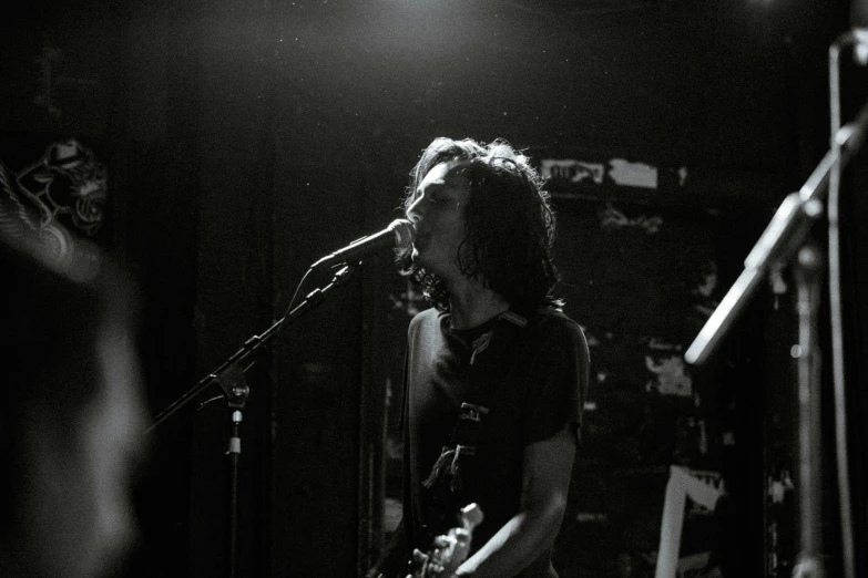 a young person is singing and playing the guitar on stage