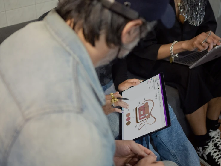 people sitting in a room using laptops while looking at information