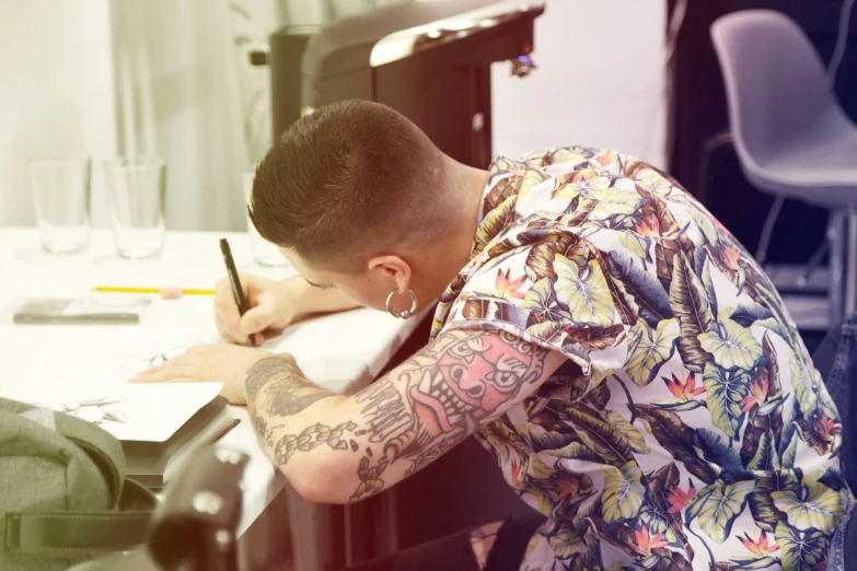 a man writing on a notepad with a pen