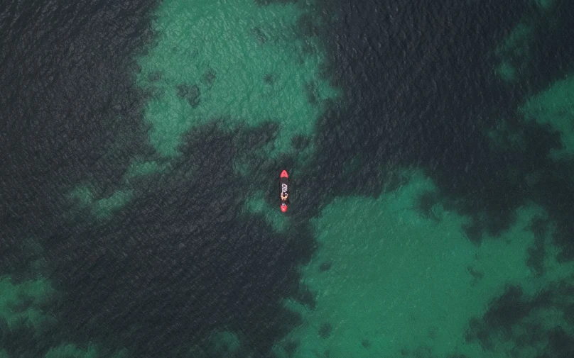 two boats float together in clear water next to an island