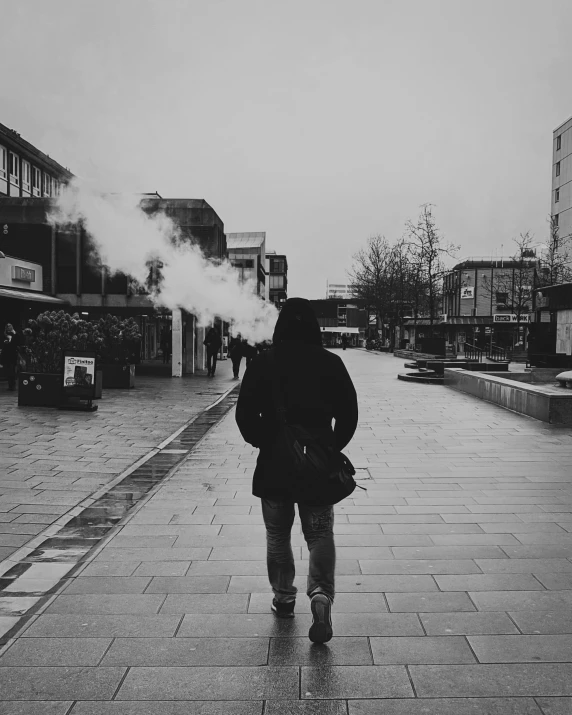 a person with a bag on the street smoking some smoke