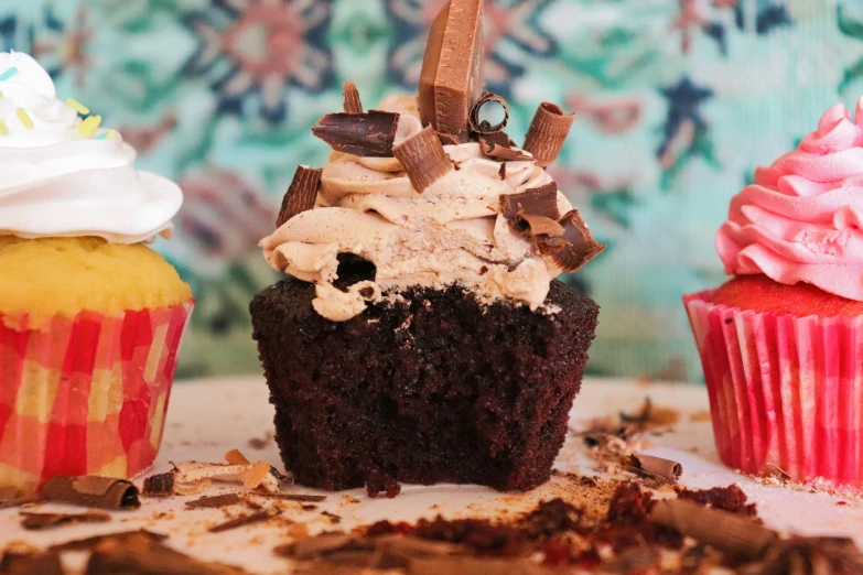 a table topped with four different types of cupcakes