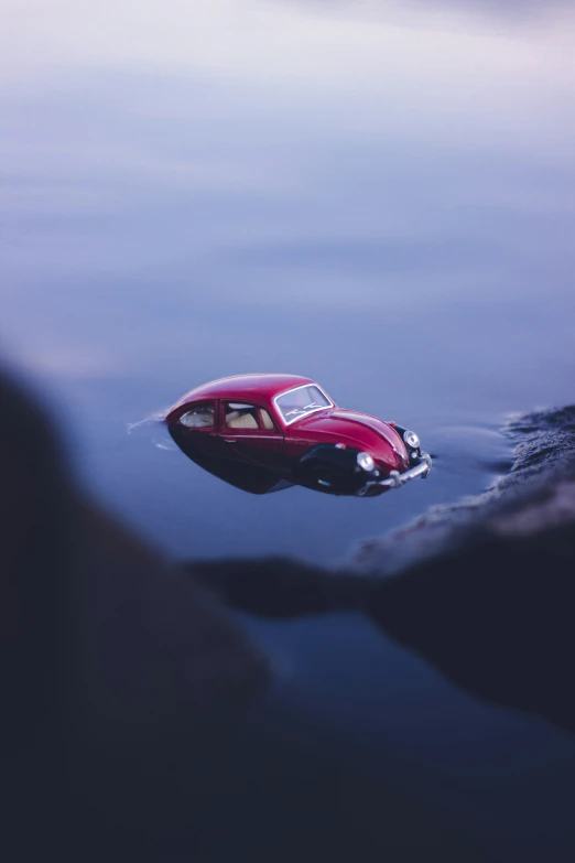 red car with the hood up is in the water