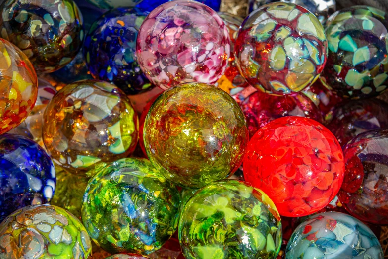 lots of different colored glass balls in a box