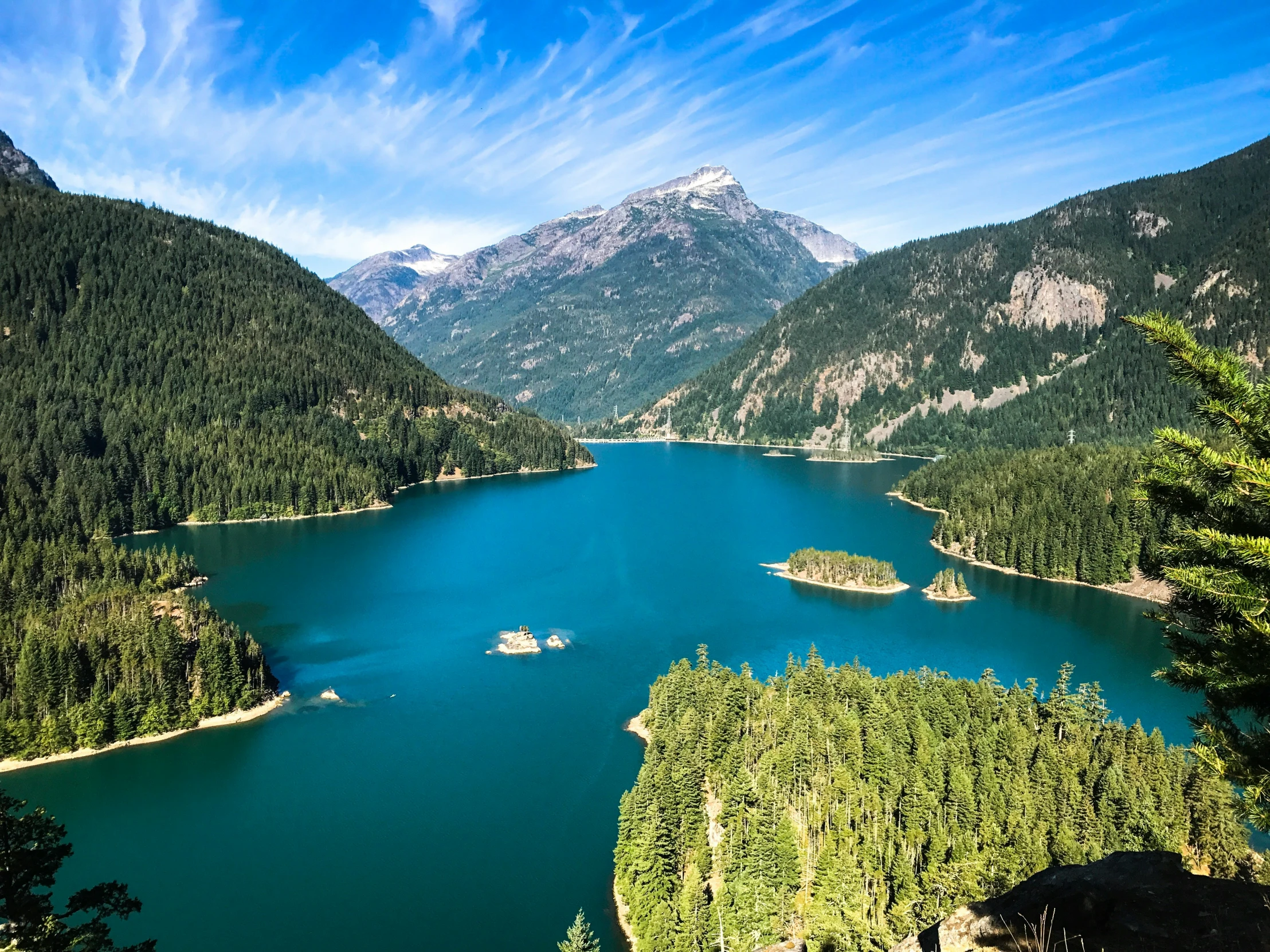 a mountain is shown with some water and trees