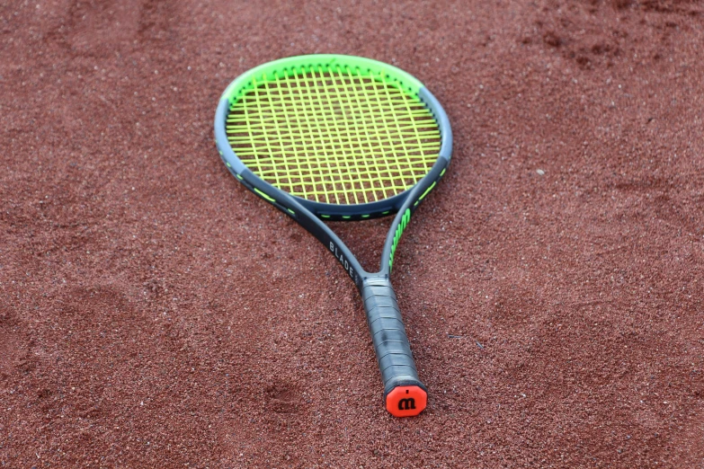 a tennis racket is laying on the sand