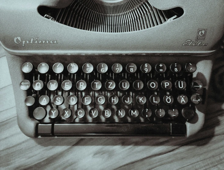 an old fashioned typewriter sitting on top of a wooden table