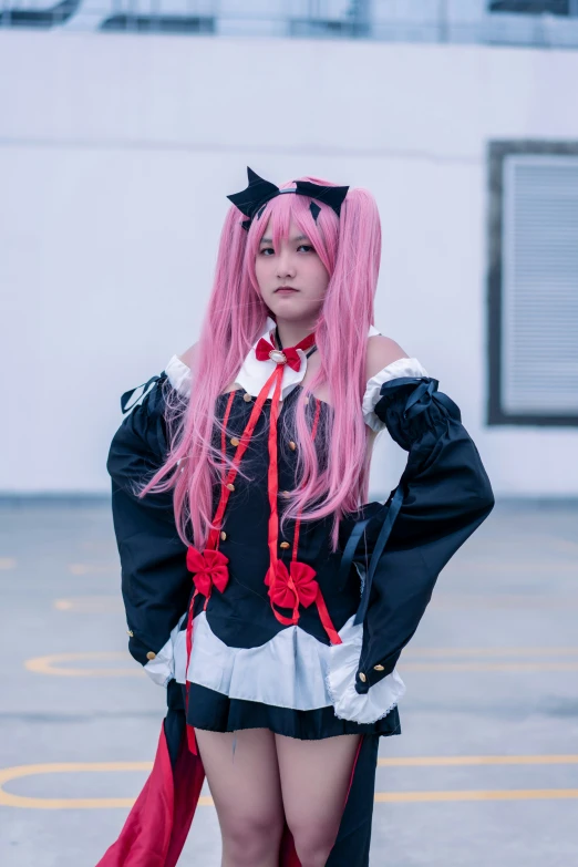 a person in black and white cosplay with pink hair posing for the camera