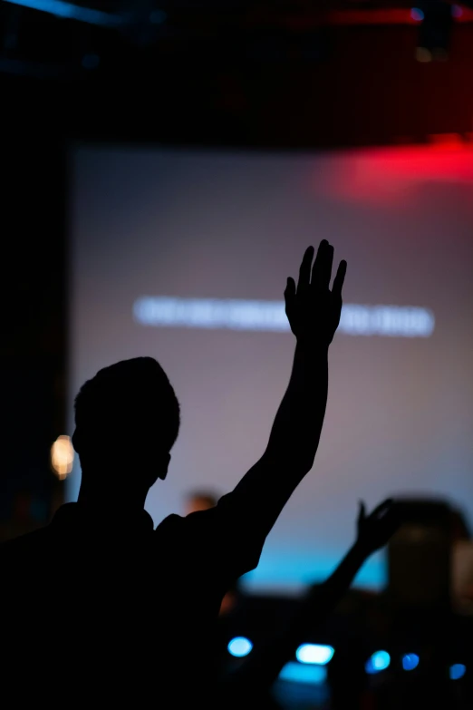 man making speech at a speaker in front of a screen