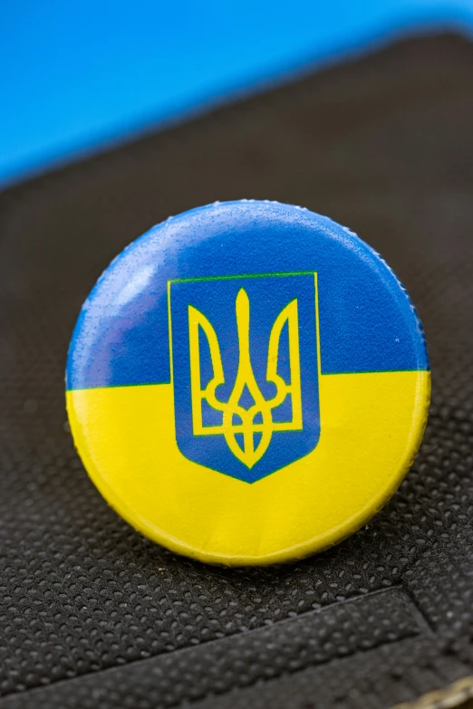 a blue and yellow badge is on a black piece