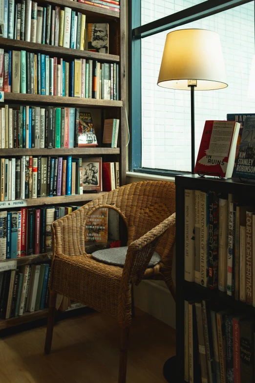 the chair is by a big bookshelf with many books