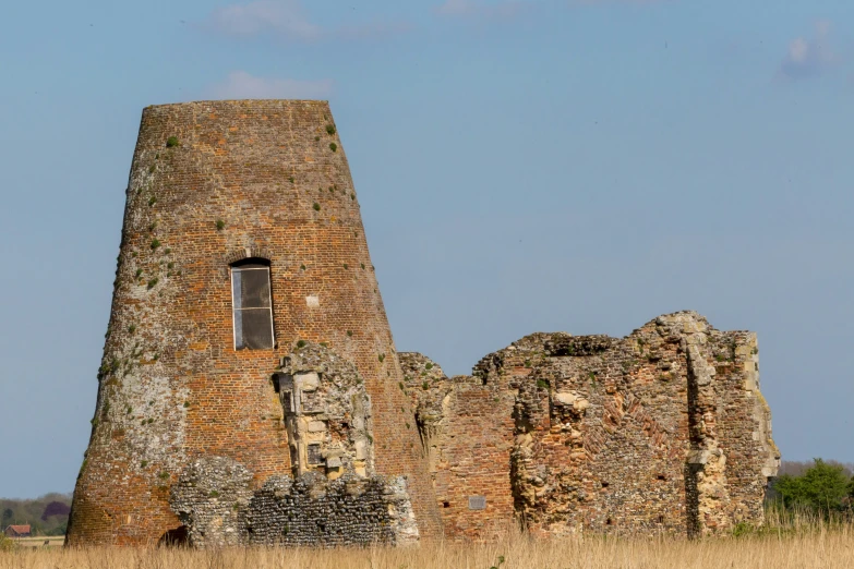 an old brick tower in the middle of a field