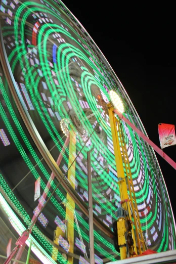 a large ferris wheel lit up with green lights