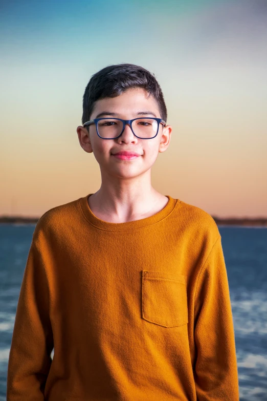 a  with glasses standing by a body of water