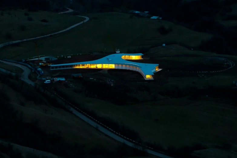 the side of an airplane with a lit building in the middle