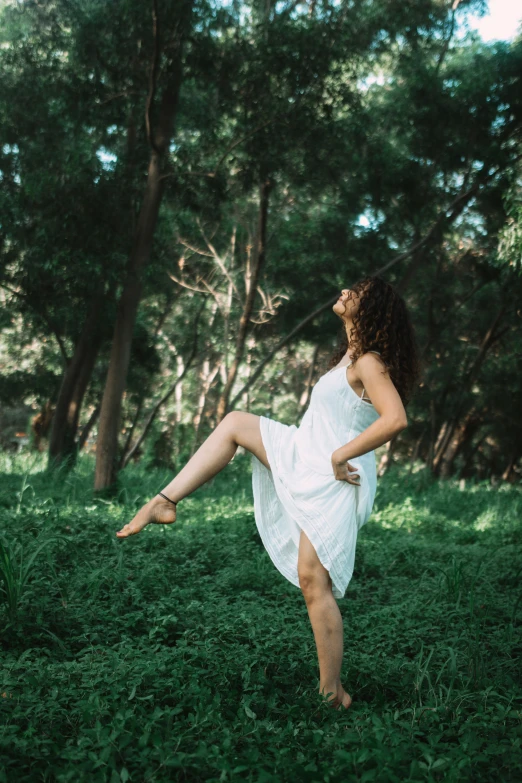 the woman in white is dancing around in the green