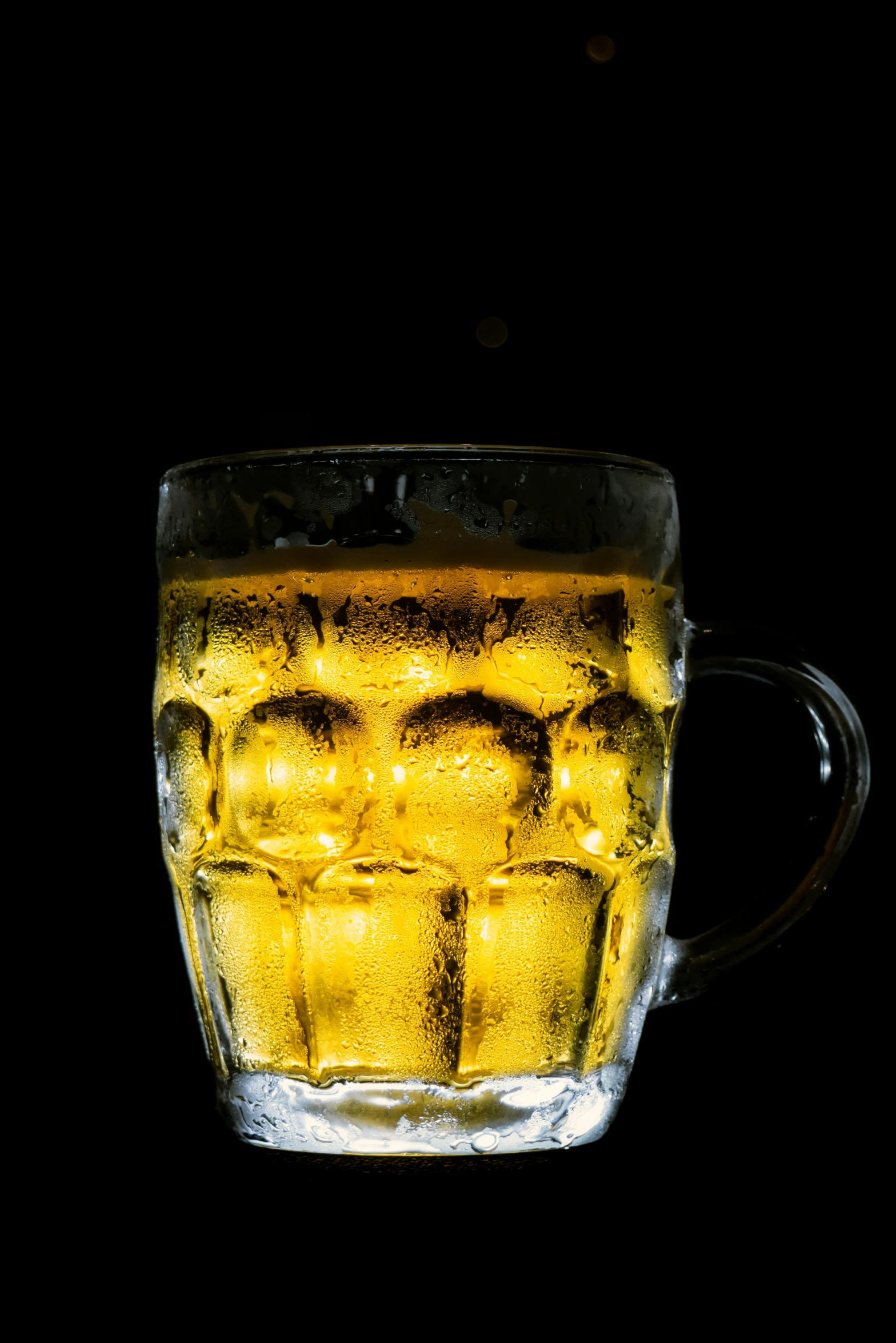 a mug with ice cubes in it against a black background
