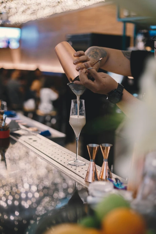 a person pouring a drink into a glass