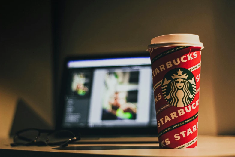 a starbucks cup sitting in front of a computer