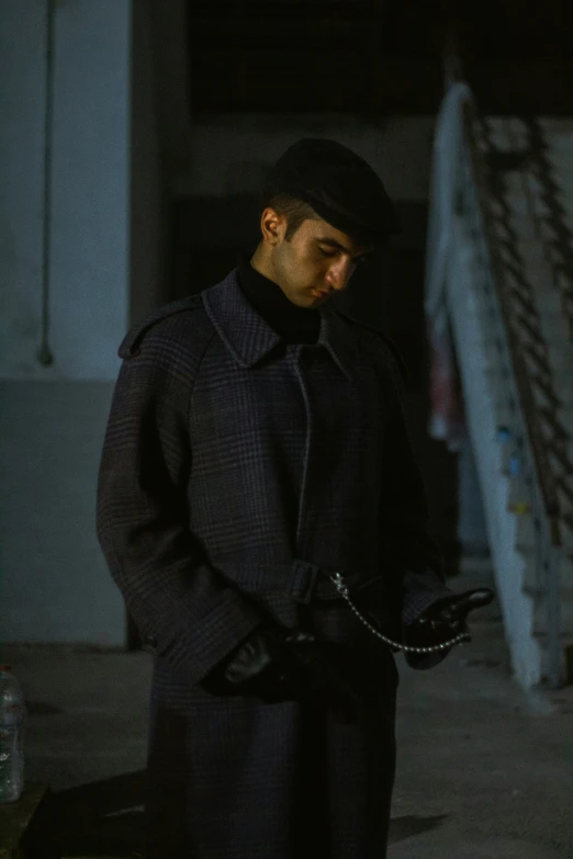 a man standing next to a blue fence at night