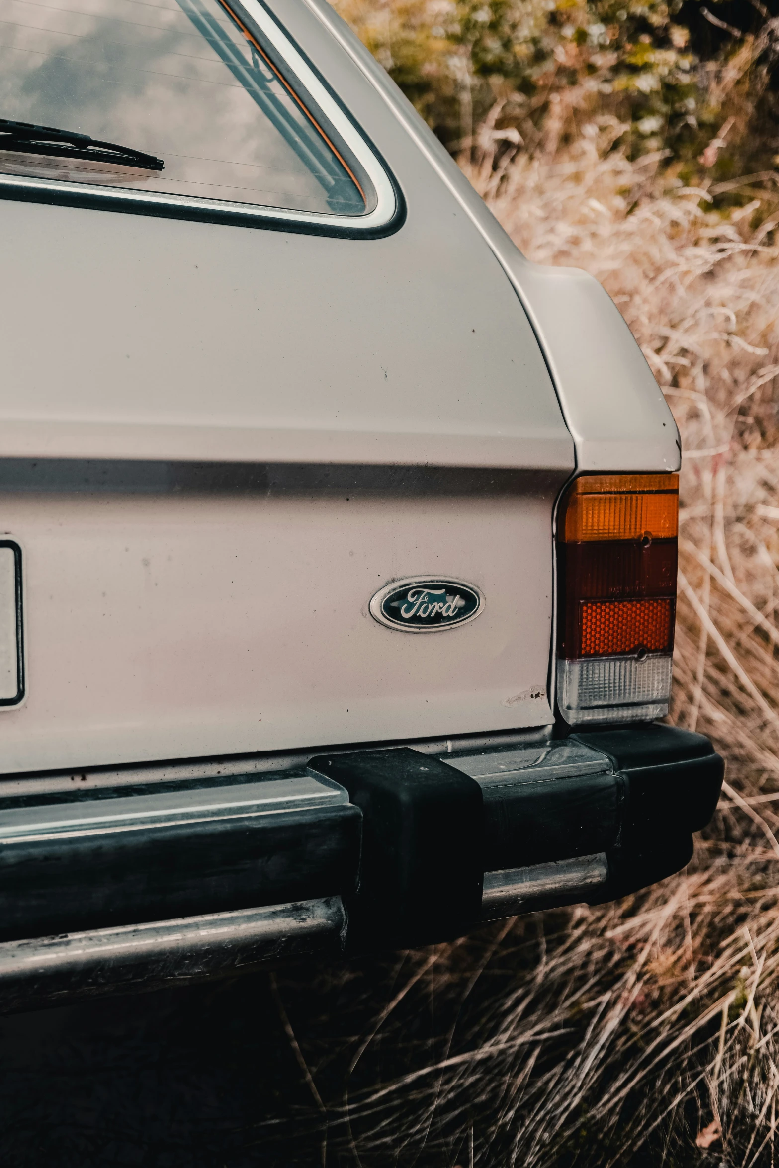 a white car sitting on top of a field of grass