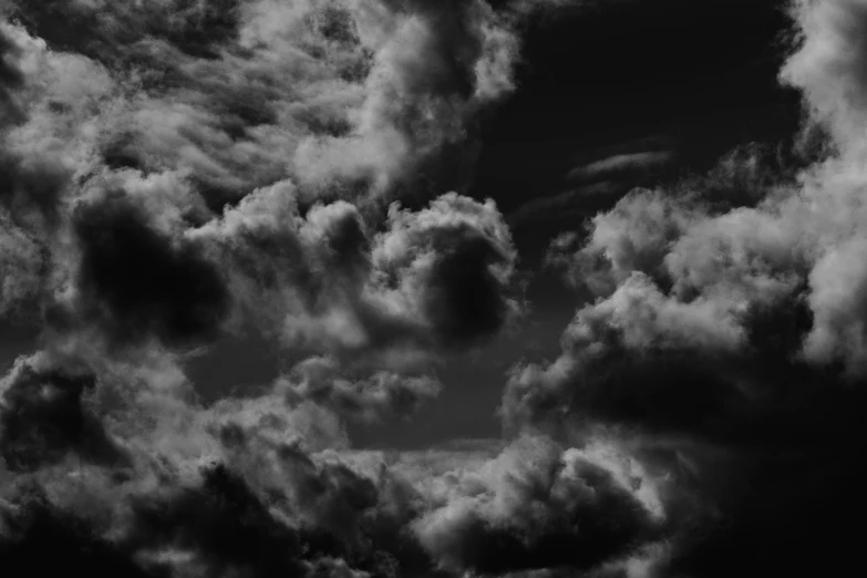 dark clouds hover above the horizon and surround the blue sky