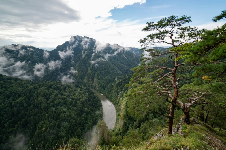 a scenic view of a mountain and river in the mountains