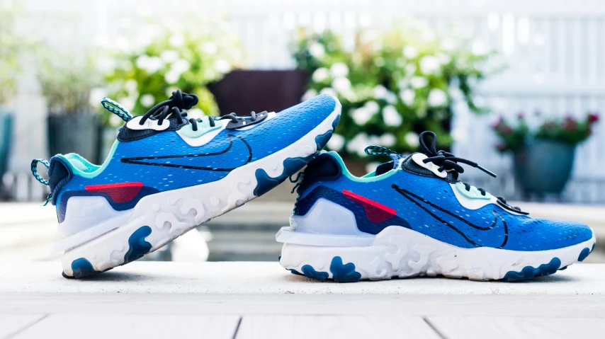 two pairs of nike react sneakers are shown in bright blue