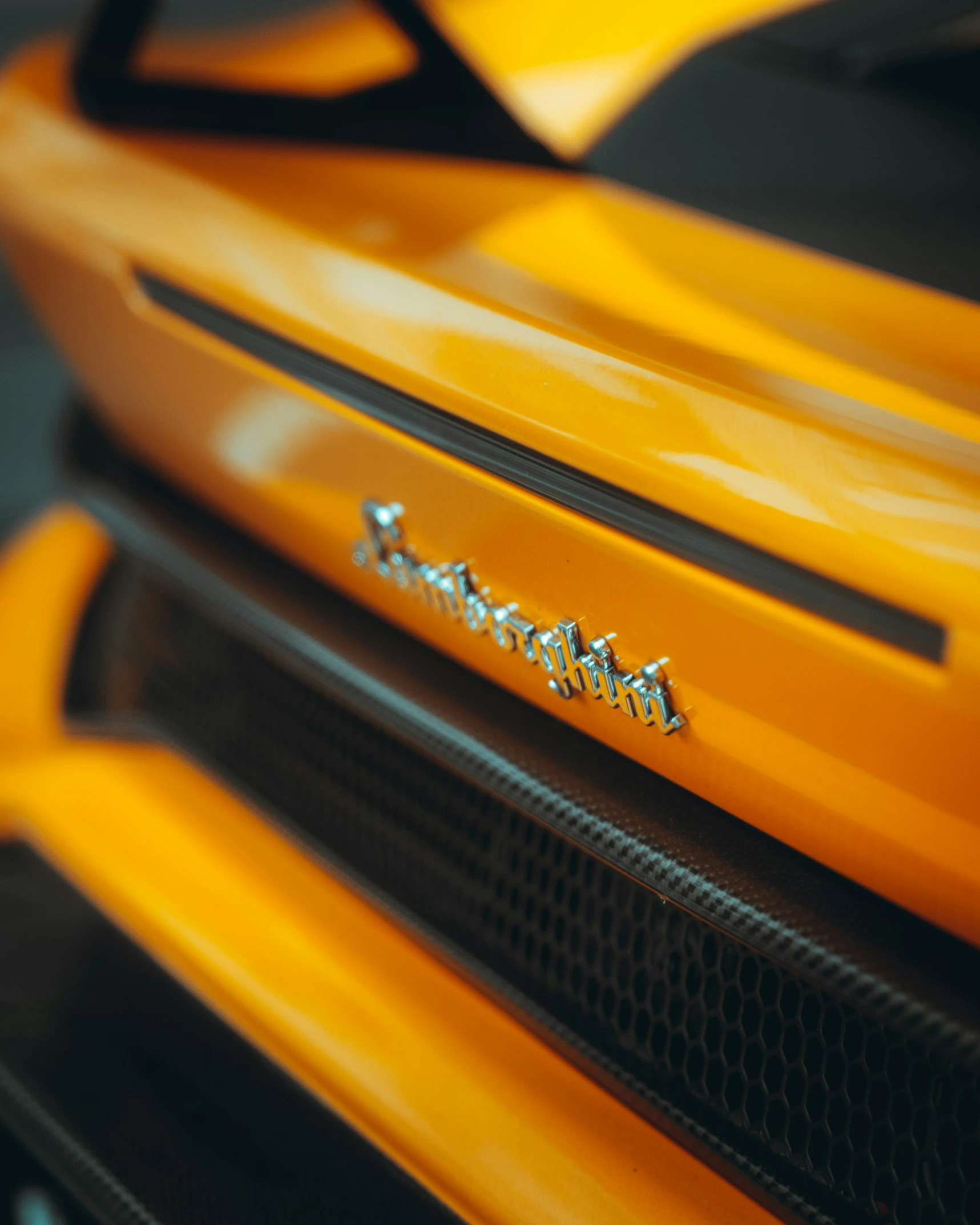 an orange sports car has a silver name plate