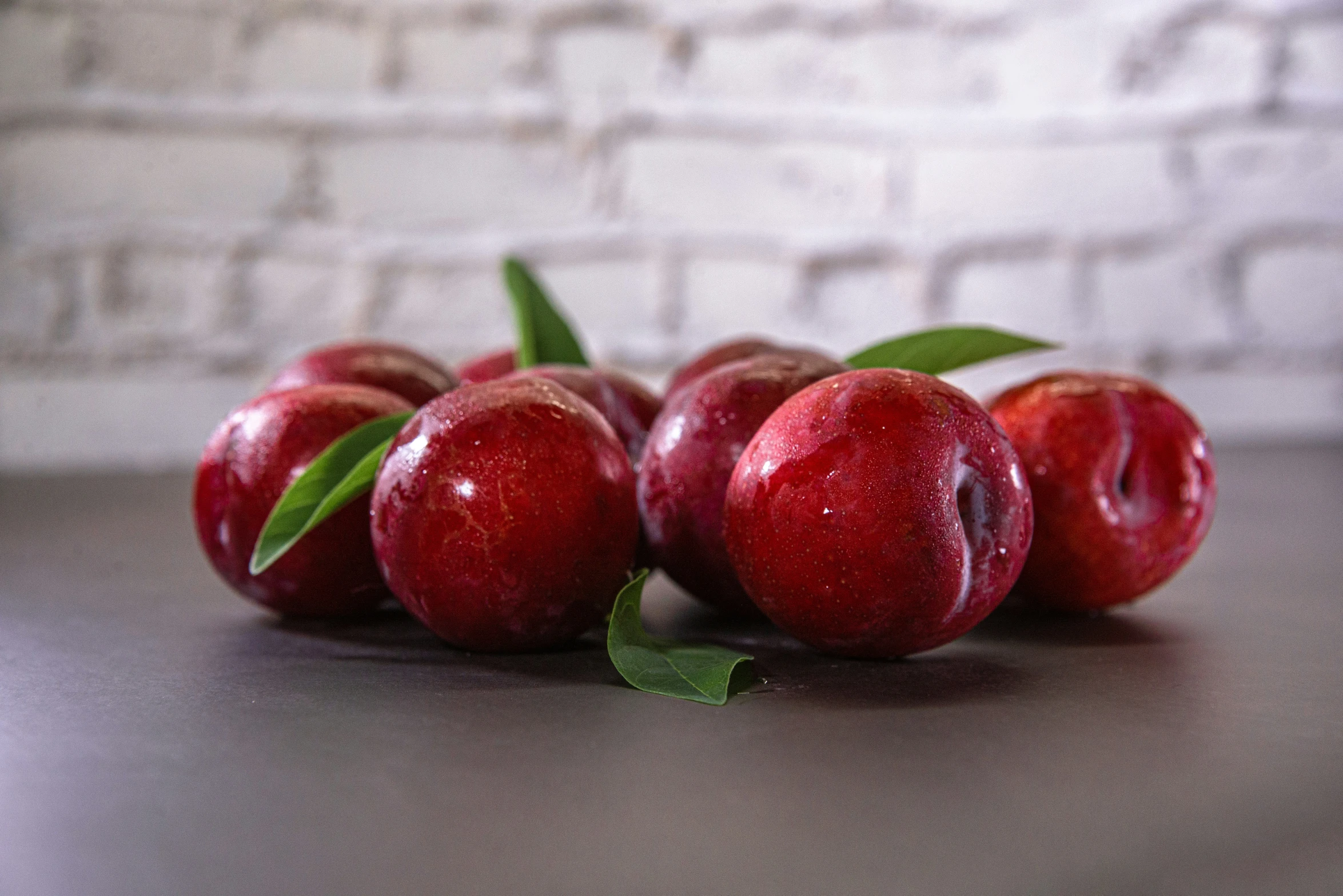 three apples sit next to each other with green leaves on the stems