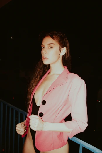 a lady posing at night with her shirt off and jacket down