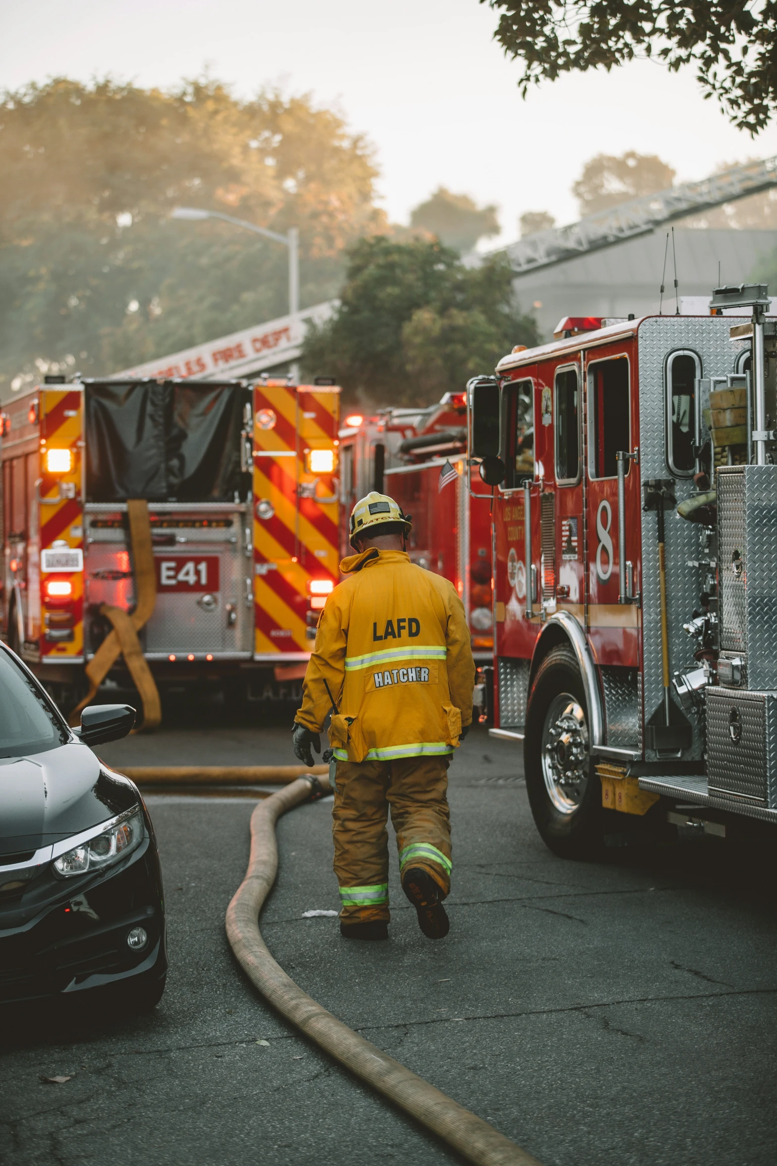 a firefighter walks toward his vehicles and emergency vehicles