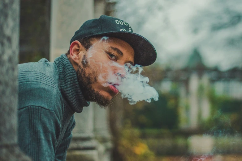 man smoking on a phone with his hands behind him